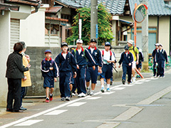【写真】沿道を歩く子どもたちと応援している地域の人
