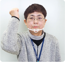 手話通訳者・鈴木さんがグーに握った手を右耳脇で下に下そうとしている写真