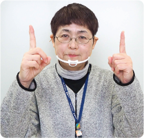 手話通訳者・鈴木さんが両手人差し指を30センチほどの間隔を空け、顔の前に出している写真