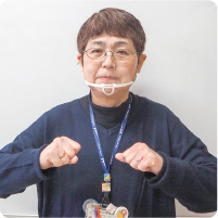 手話通訳者・鈴木さんが胸の高さで両手をグーに握っている写真