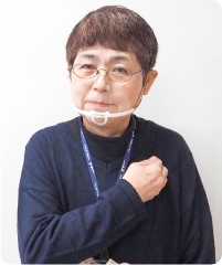 手話通訳者・鈴木さんが右手を左肩に置いている写真