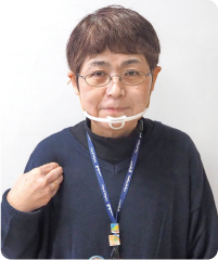 手話通訳者・鈴木さんが右手を右肩に置いている写真