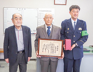 交通安全功労者表彰を受けた風間兵司さんが表彰状を持ち、新潟南警察署長たちと並んでいる写真