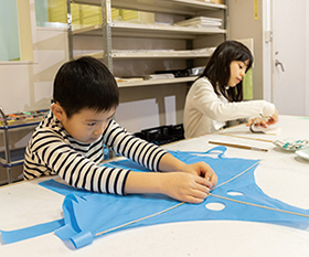 ミニ凧を作っている男の子と女の子の写真