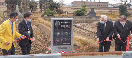 田沢実入顕彰碑の除幕式で南区長たちが顕彰碑を見ている写真