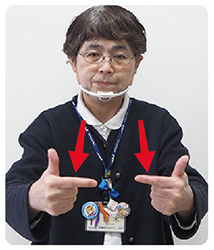 手話通訳者・鈴木さんがそのL字にした指を前に出している写真