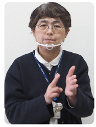 手話通訳者・鈴木さんが手の平を縦にし、もう片方の手チョキにしている写真