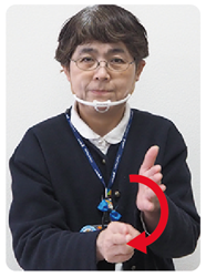 手話通訳者・鈴木さんがチョキの方の手をぐるっと縦に回している写真