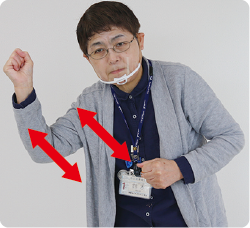 手話通訳者・鈴木さんが両手を握り斜めに上下させている写真