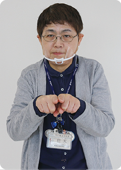 手話通訳者・鈴木さんが胸の前で人差し指と中指をくっ付けている写真
