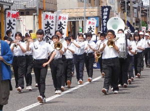 中学校の吹奏楽部が市中パレードでマーチングをしている写真