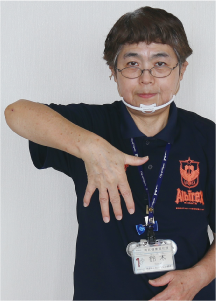 手話通訳者・鈴木さんが５本の指を開き下向きにしている写真