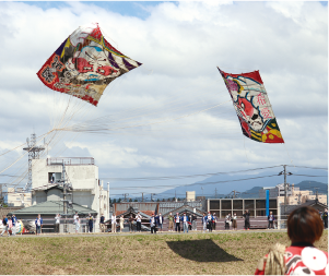 中ノ口川上空に東西から揚がる大凧２枚の写真