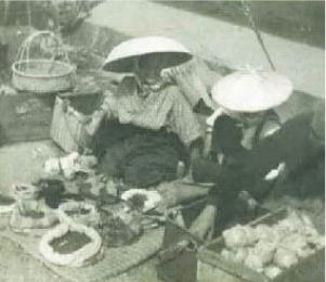 市で梨や豆を売る女性の写真