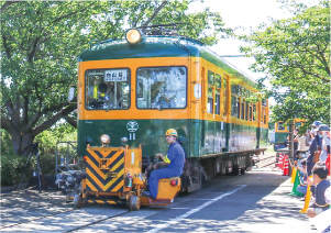 かぼちゃ電車保存会のメンバーが鉄道車両用車両移動機「アント」を運転し、かぼちゃ電車を動かしている写真
