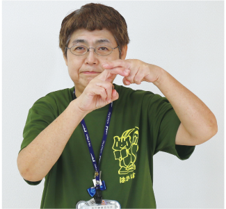 手話通訳者・鈴木さんが両手をチョキにして上にする方は真っすぐに伸ばし、下にする方はチョキにした2本の指を曲げて、上の指に付けている写真