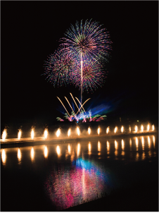 ユーザーネーム「quz.sk」さん。たくさんの小さな花火が一列に上がり、その真ん中に大きな打ち上げ花火が上がっている、白根大凧合戦花火大会の写真