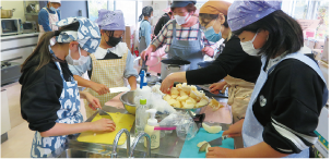 「地域の食堂カレー屋さん」で子どもたちが食材を切っている写真
