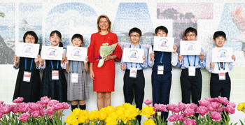 朱鷺メッセで各国代表らを笑顔で出迎える万代長嶺小学校の児童と宮浦中学校の生徒