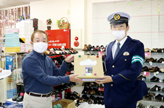 【写真】イザワ靴店店主（左）と秋葉警察署齋藤交通課長（右）