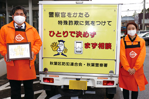 【写真】車体に防犯ステッカーを貼ったとくし丸、（株）カワマツの鈴木さんと澤口さん