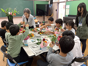 小合小学校の児童が生け花を教わっている様子を撮った写真