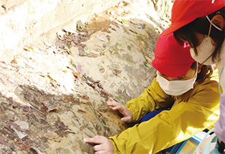 地層の土を触る児童たちの様子を撮った写真