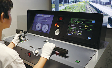 電車運転シミュレーターを操作する子どもの写真