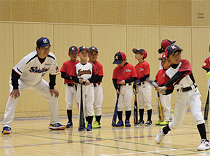 こどもたちに指導する元東京ヤクルトスワローズの本間忠さんの写真