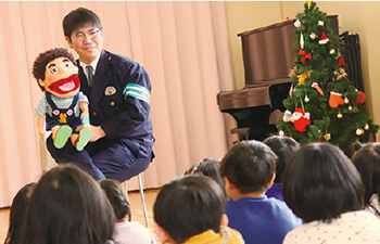 腹話術でこどもたちに指導をしている警察署員の写真