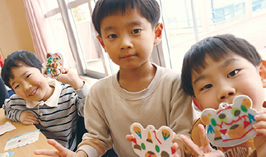 自分たちで作成した反射材キーホルダーを手に取る園児たちの写真