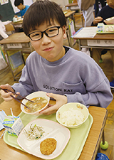 秋葉区産農産物を使用した給食を食べる生徒の写真