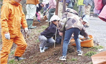地元住民とAkiha森のようちえん園児たちと共に植樹をしている様子
