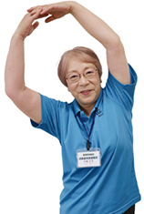 両手で頭上に大きな輪を作っている加藤正子さんの写真