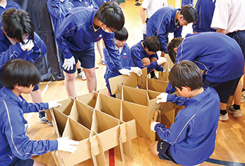 段ボールベッドをみんなで組み立てる様子