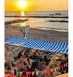 写真　夕暮れの関屋浜でバーベキューを楽しむ人々