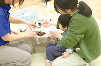 写真　手形足形クリスマスオーナメントをつくる親子の様子