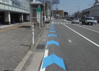 青い矢羽根型の路面表示
