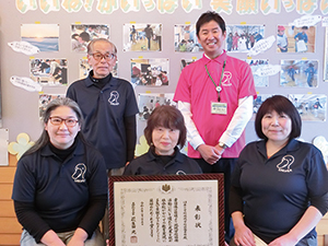 臼井小学校の地域教育コーディネーターの先生方が表彰状を持っている写真