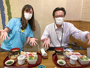 前田さんと参加者が定食を前にしてポーズをとる写真