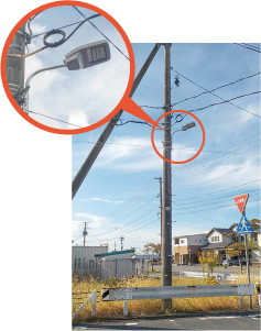 道路照明灯が取り付けられた電信柱全体と道路照明灯のアップ写真