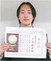 小島幹栄(こじま みきひさ)さんが最優秀競技者賞の賞状と盾を持っている写真
