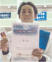柳橋 成(やなぎばし じょう)さんが大会の賞状と記念品を持っている写真