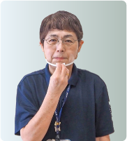 手話通訳者・鈴木さんが指をすぼめて顎に置いている写真