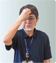 手話通訳・鈴木さんが指をすぼめて額に置いている写真