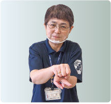 手話通訳者・鈴木さんが片手をチョキにした手の甲の上にもう片方の手をグーにして乗せ　　ている写真