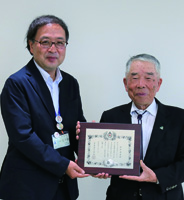 区社会福祉協議会会長の田中清彦さんと区長が、表彰状を持っている写真