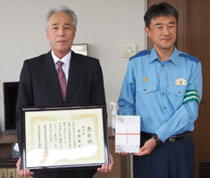 区交通安全協会副会長の風間茂樹さんと新潟南署長が、表彰状を持っている写真