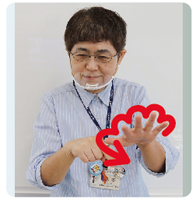 手話通訳者・鈴木さんがその人差し指で左手の指をなぞっていっている写真