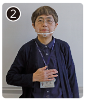 手話通訳・鈴木さんが手の平を胸の真ん中に置いている写真